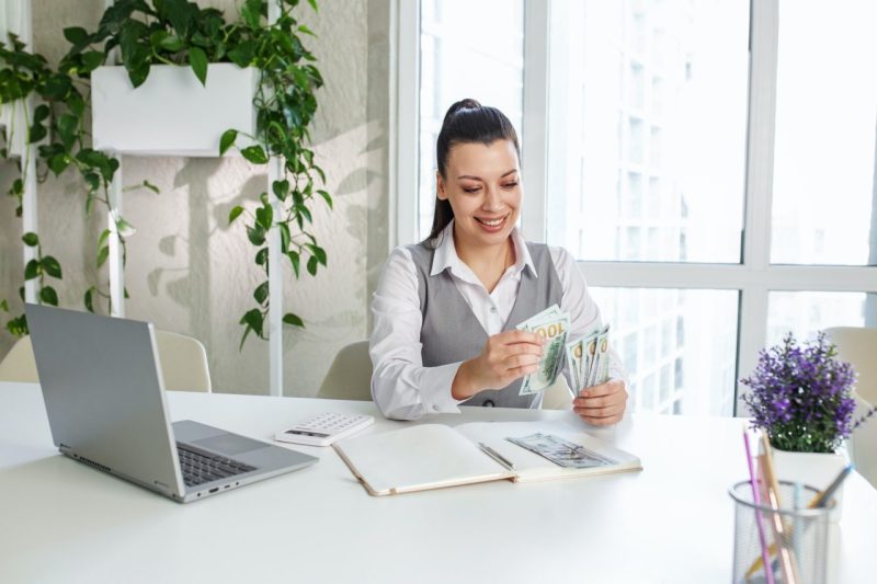 Biganto Nova 1 success woman worker counting dollars at modern office achievement career concept 800x533 1