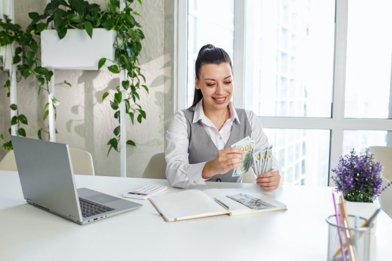 success woman worker counting dollars at modern office achievement career concept 800x533 1